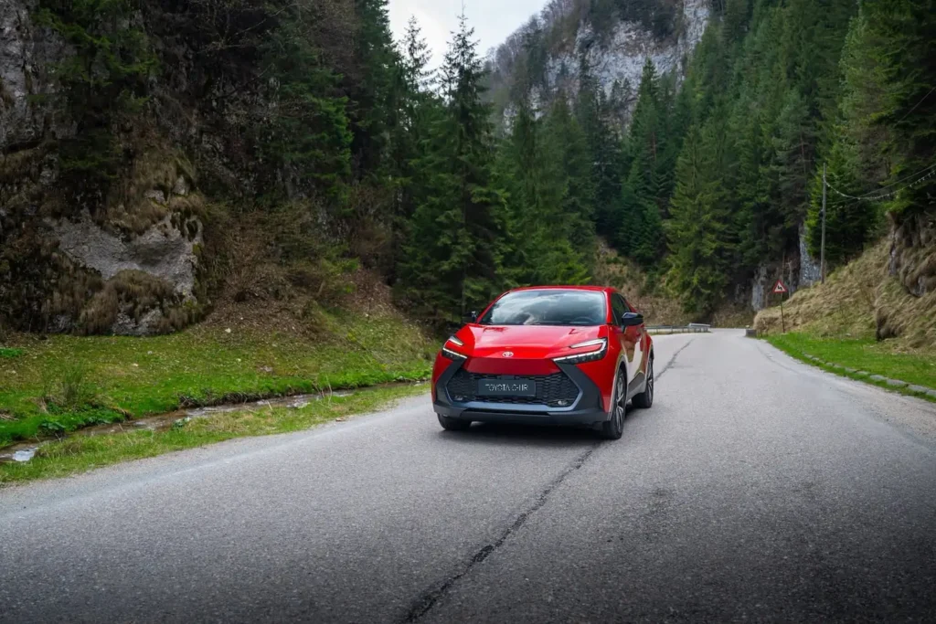 Toyota C-HR roșu pe un drum de munte